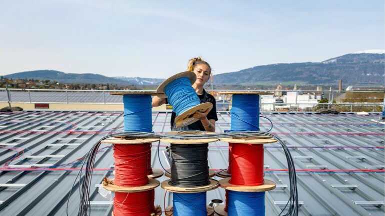 Stromkabelrollen und eine BKW-Installateurin.